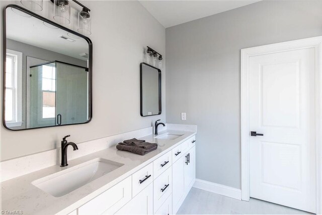 112 Emerald Ct, Trinity, NC 27370 - full bathroom with double vanity, baseboards, and a shower with door