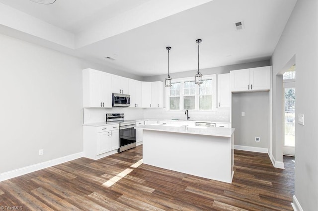 112 Emerald Ct, Trinity, NC 27370 - kitchen featuring appliances with stainless steel finishes, dark wood-style floors, baseboards, and white cabinets
