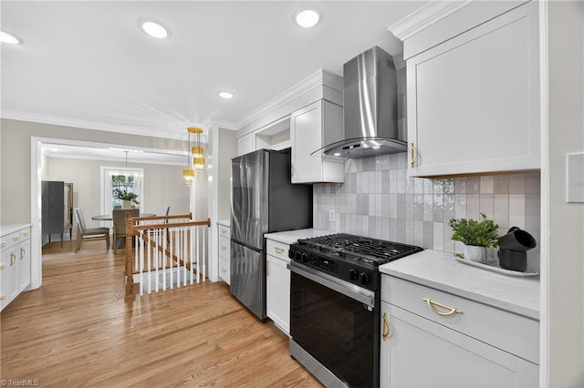 506 Audubon Dr, Greensboro, NC 27410 - kitchen featuring gas stove, freestanding refrigerator, wall chimney exhaust hood, ornamental molding, and white cabinets