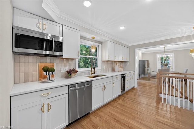 506 Audubon Dr, Greensboro, NC 27410 - kitchen with appliances with stainless steel finishes, ornamental molding, wine cooler, white cabinets, and healthy amount of natural light