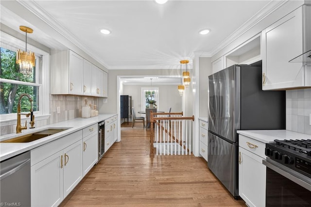 506 Audubon Dr, Greensboro, NC 27410 - kitchen with appliances with stainless steel finishes, light wood finished floors, white cabinets, light countertops, and decorative backsplash
