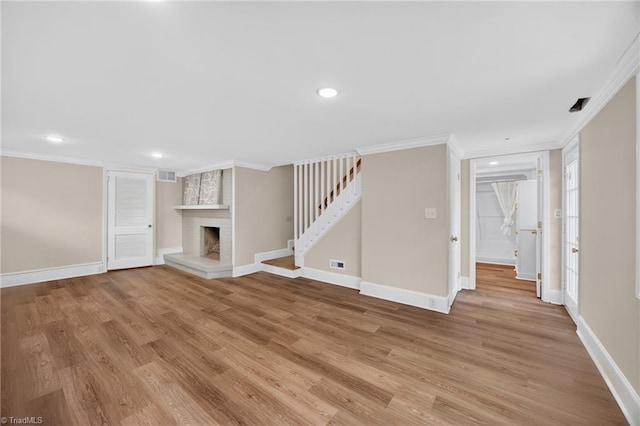 506 Audubon Dr, Greensboro, NC 27410 - unfurnished living room with ornamental molding, light wood finished floors, recessed lighting, a fireplace, and stairway