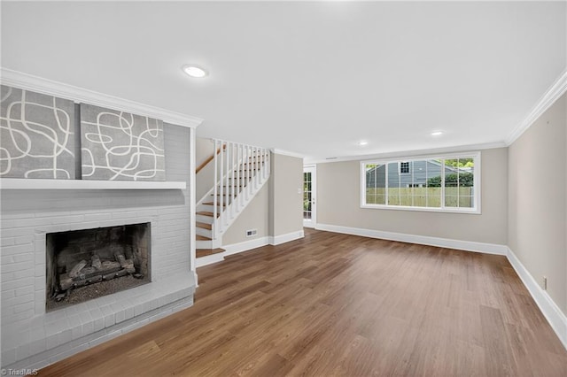506 Audubon Dr, Greensboro, NC 27410 - unfurnished living room with ornamental molding, stairway, wood finished floors, a fireplace, and recessed lighting