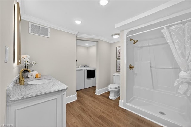 506 Audubon Dr, Greensboro, NC 27410 - full bath featuring washer and dryer, crown molding, vanity, a shower with shower curtain, and wood finished floors