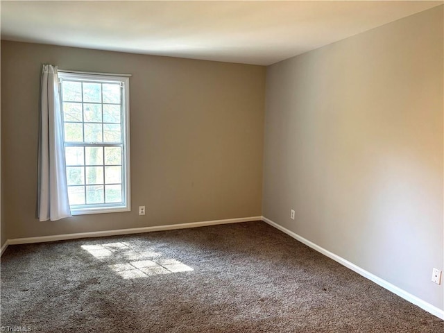 empty room featuring carpet floors and baseboards