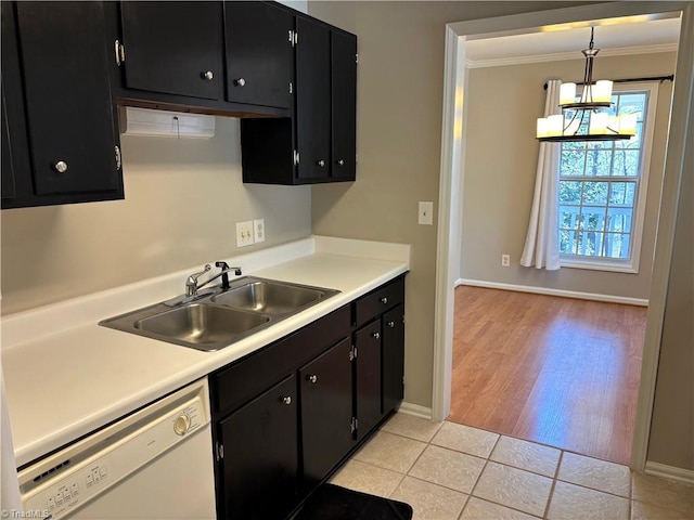 kitchen with white dishwasher, light tile patterned flooring, a sink, dark cabinetry, and crown molding