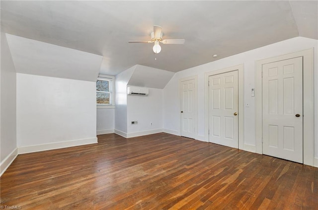 bonus room with vaulted ceiling, dark wood-type flooring, a wall mounted air conditioner, and ceiling fan