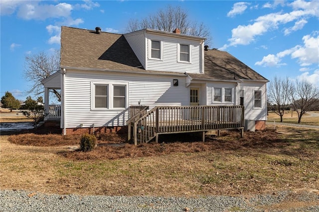 rear view of house featuring a wooden deck and a yard