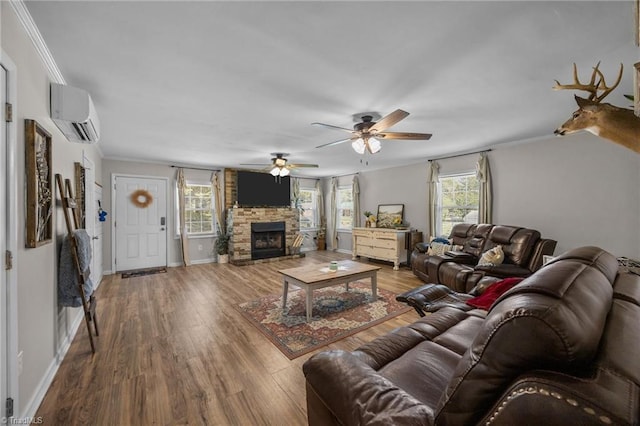202 Stokes Forest Dr, King, NC 27021 - living room with a wall mounted AC, wood finished floors, ornamental molding, a fireplace, and ceiling fan