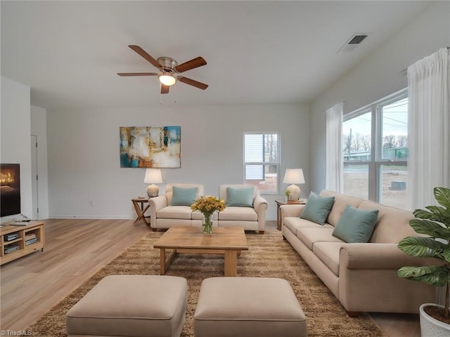 living room with light hardwood / wood-style floors and ceiling fan