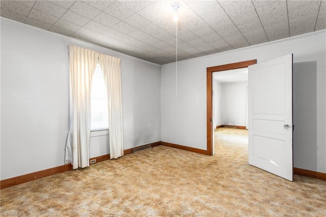 empty room featuring ornamental molding and light colored carpet