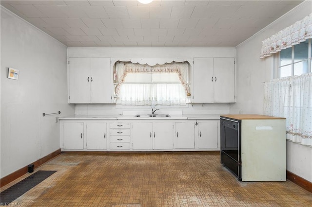 kitchen featuring black dishwasher, white cabinets, sink, and crown molding