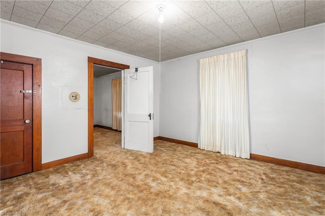 empty room with crown molding and carpet