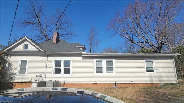 back of property with crawl space, central AC, and a chimney
