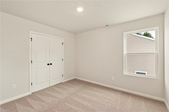 spare room featuring light colored carpet