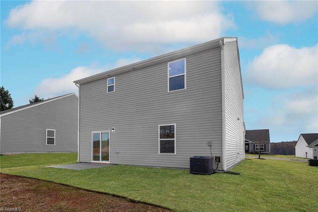 rear view of house with central AC unit, a patio area, and a yard