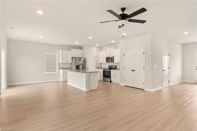 kitchen featuring white cabinetry, an island with sink, stainless steel appliances, and light hardwood / wood-style floors