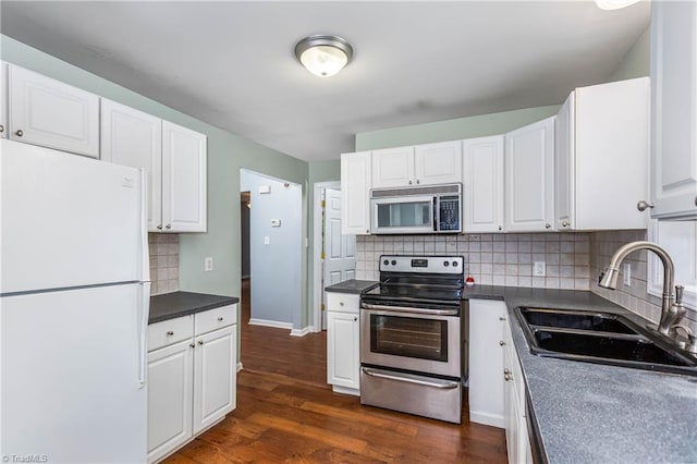 1093 Gordon Rd, Pinnacle, NC 27043 - kitchen featuring appliances with stainless steel finishes, white cabinets, decorative backsplash, dark wood finished floors, and dark countertops