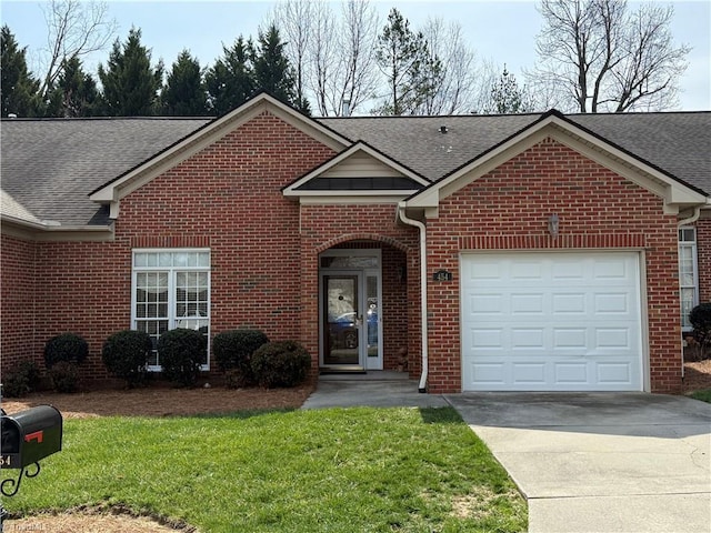 view of front of home with driveway, roof with shingles, a front yard, an attached garage, and brick siding