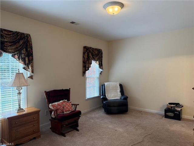 sitting room with carpet flooring, visible vents, and baseboards