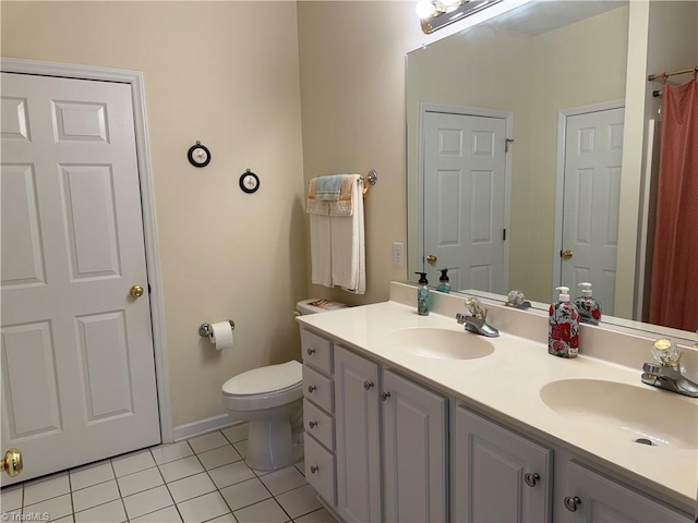 bathroom featuring a sink, toilet, double vanity, and tile patterned floors