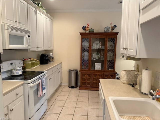 kitchen featuring white appliances, crown molding, light countertops, and a sink