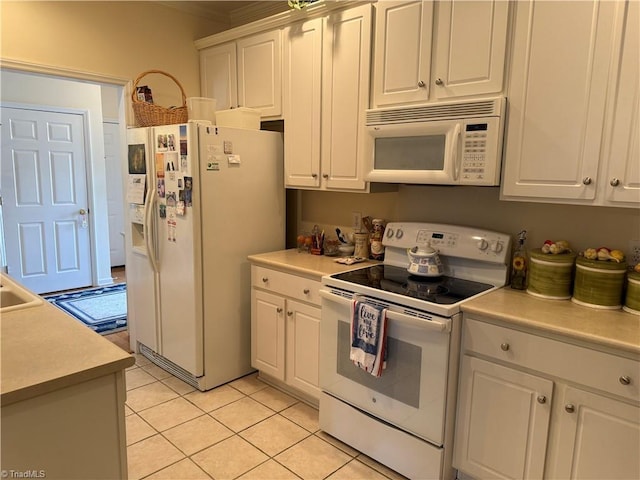 kitchen with white appliances, white cabinetry, and light countertops