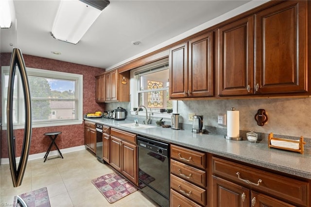 kitchen featuring a sink, backsplash, refrigerator, baseboards, and dishwasher