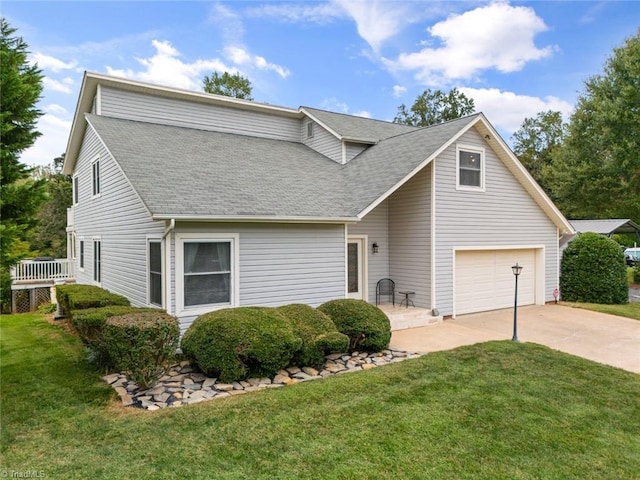 traditional-style house featuring concrete driveway, a front yard, and a shingled roof