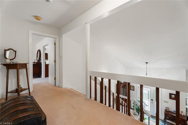 hall featuring an upstairs landing and carpet flooring