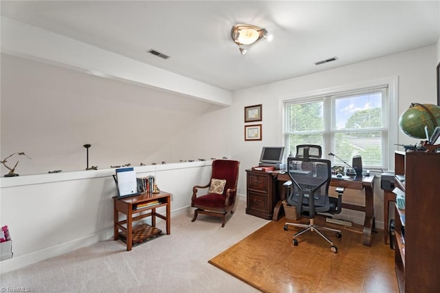 carpeted office space featuring lofted ceiling with beams, baseboards, and visible vents