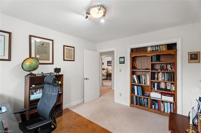 carpeted home office with baseboards