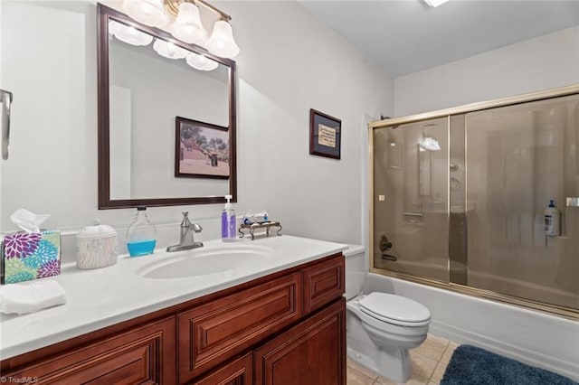 bathroom featuring tile patterned flooring, toilet, an inviting chandelier, enclosed tub / shower combo, and vanity