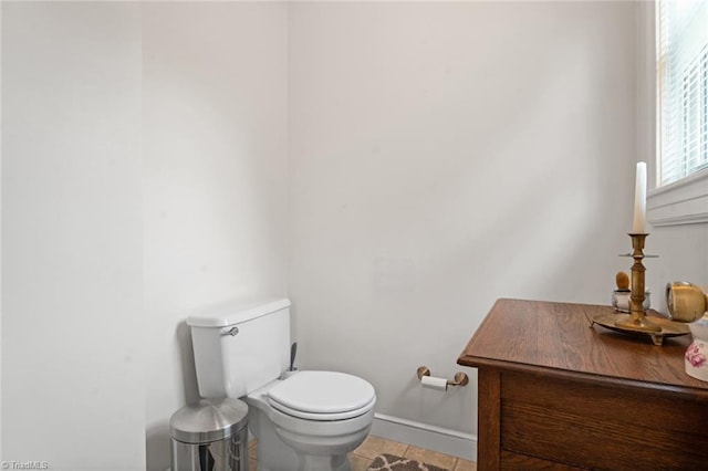 bathroom featuring tile patterned flooring, toilet, and baseboards