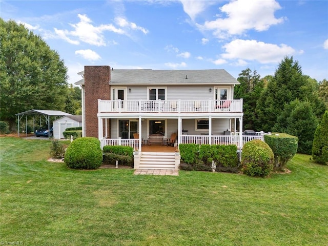 back of property featuring a carport, a lawn, and a balcony