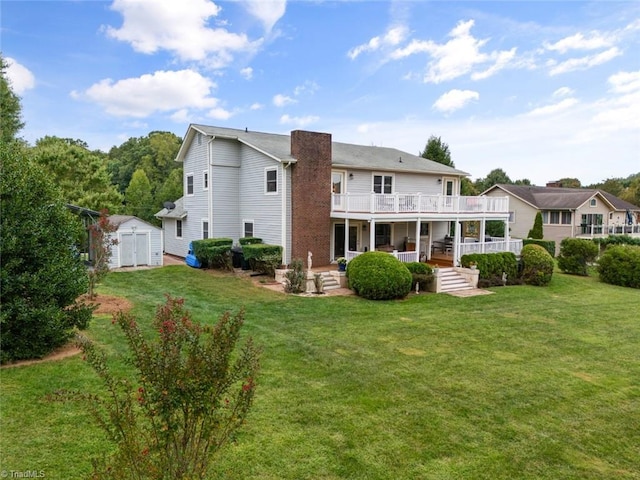 back of property with a yard, an outbuilding, a storage shed, and a balcony