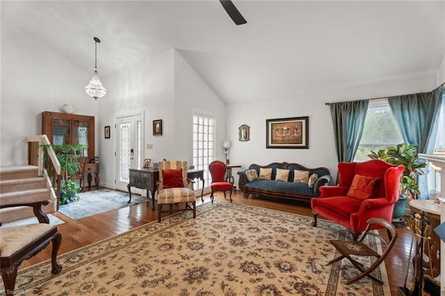 living area featuring high vaulted ceiling, a healthy amount of sunlight, wood finished floors, and a ceiling fan