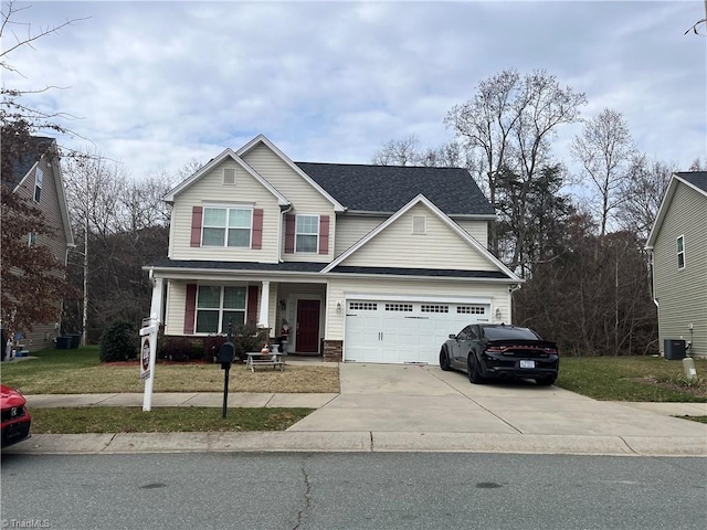 view of front of home with a front lawn, cooling unit, and a garage