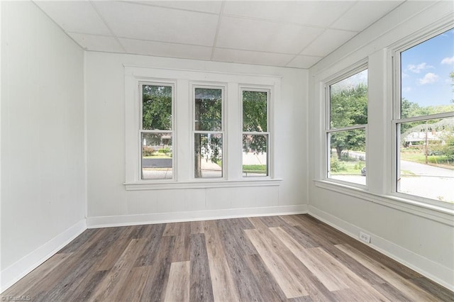 unfurnished room featuring hardwood / wood-style floors and a drop ceiling