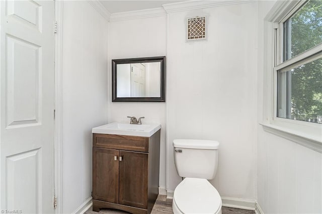 bathroom featuring ornamental molding, vanity, hardwood / wood-style floors, and toilet