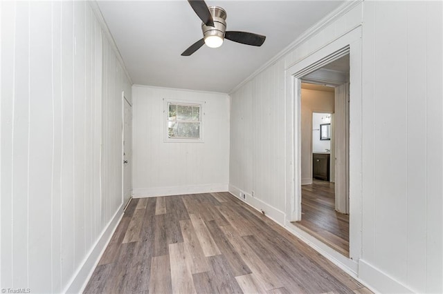 unfurnished room with ceiling fan, hardwood / wood-style flooring, and crown molding