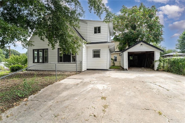 view of front of home with a garage and an outbuilding