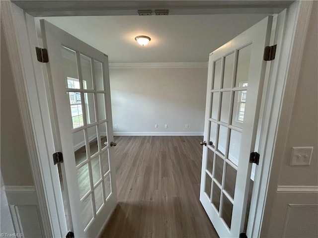 interior space featuring hardwood / wood-style flooring, crown molding, and french doors