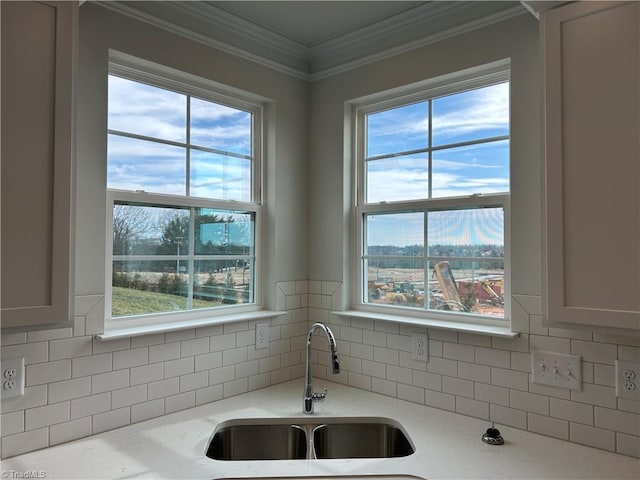 kitchen with sink, crown molding, light stone countertops, and decorative backsplash