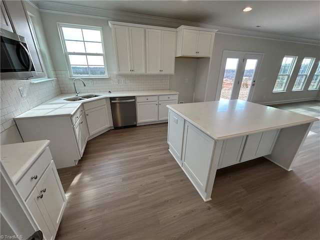 kitchen featuring a kitchen island, sink, and white cabinets