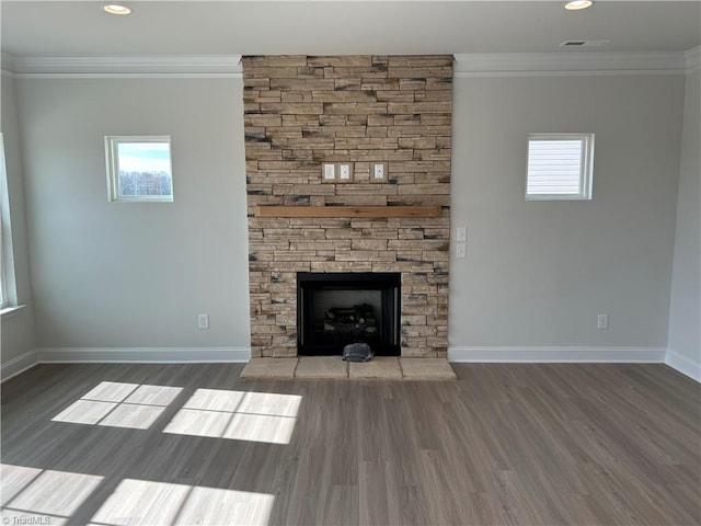 unfurnished living room featuring ornamental molding, a stone fireplace, and dark wood-type flooring