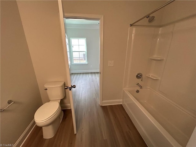 bathroom with ornamental molding, wood-type flooring, toilet, and tub / shower combination