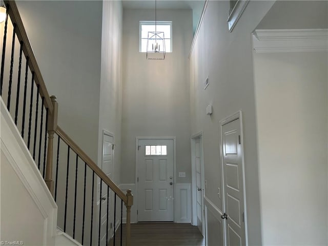 foyer with a high ceiling, dark hardwood / wood-style floors, and an inviting chandelier