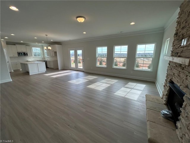 unfurnished living room featuring ornamental molding, a fireplace, and light hardwood / wood-style flooring