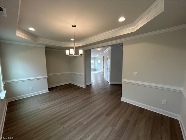 unfurnished dining area featuring an inviting chandelier, a tray ceiling, dark hardwood / wood-style flooring, and crown molding